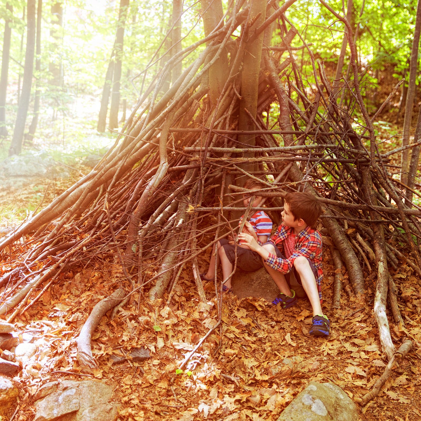 Children play in a hut out of twigs. wooden stick hut house in Children play in a hut out of twigs. wooden stick hut house in